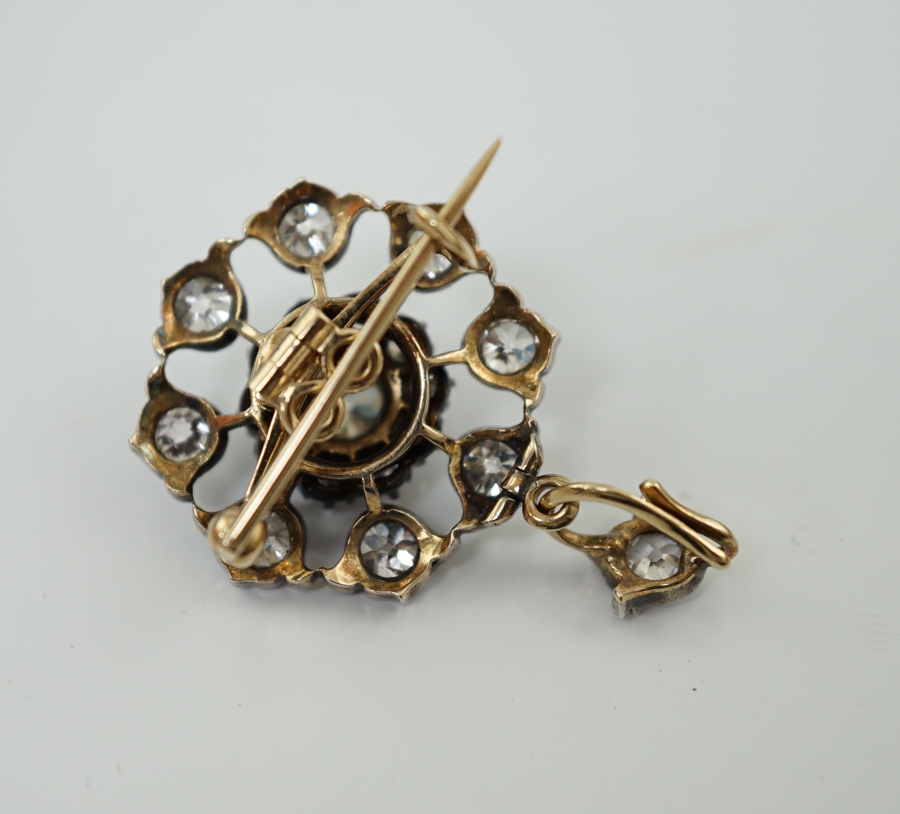 An early 20th century gold and silver mounted diamond cluster set circular pendant brooch